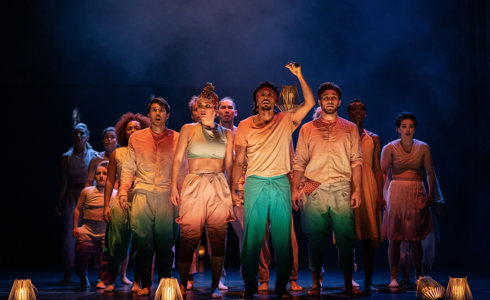 group of dancers on stage for Message in a bottle wearing colourful casual clothes looking out to the audience with one person lifting hand and clicking