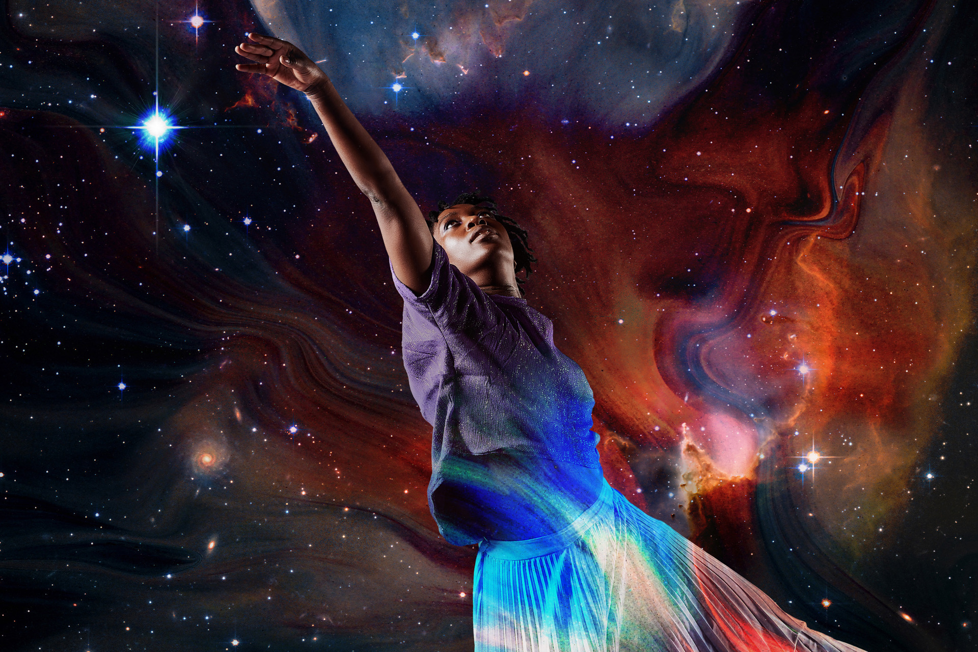 Global majority female dancer reaching to the top left on the image with a superimposed background of the galaxy Global majority female dancer reaching to the top left on the image with a superimposed background of the galaxy