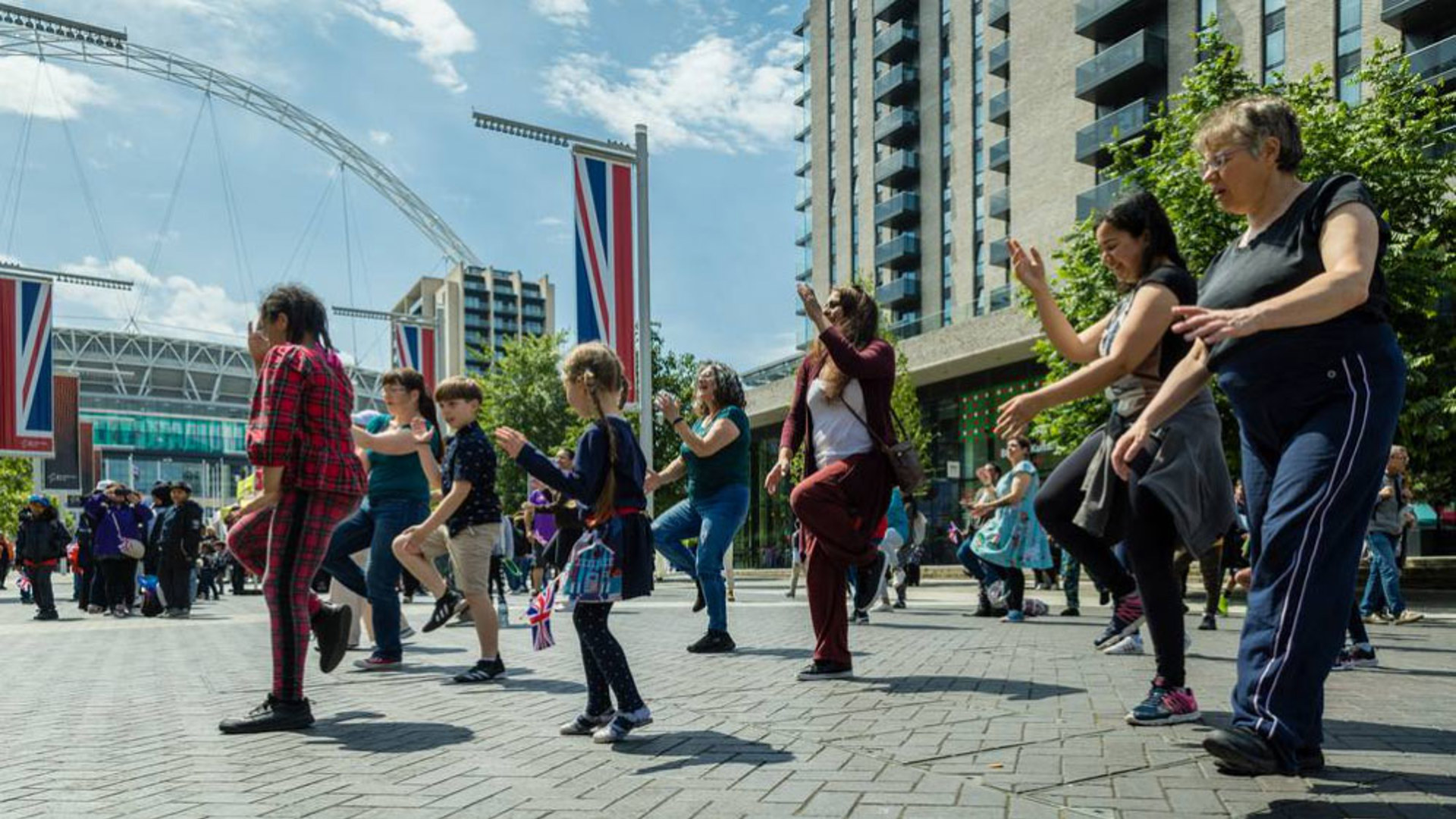 children and adults dancing in the street with large union jack flags children and adults dancing in the street with large union jack flags