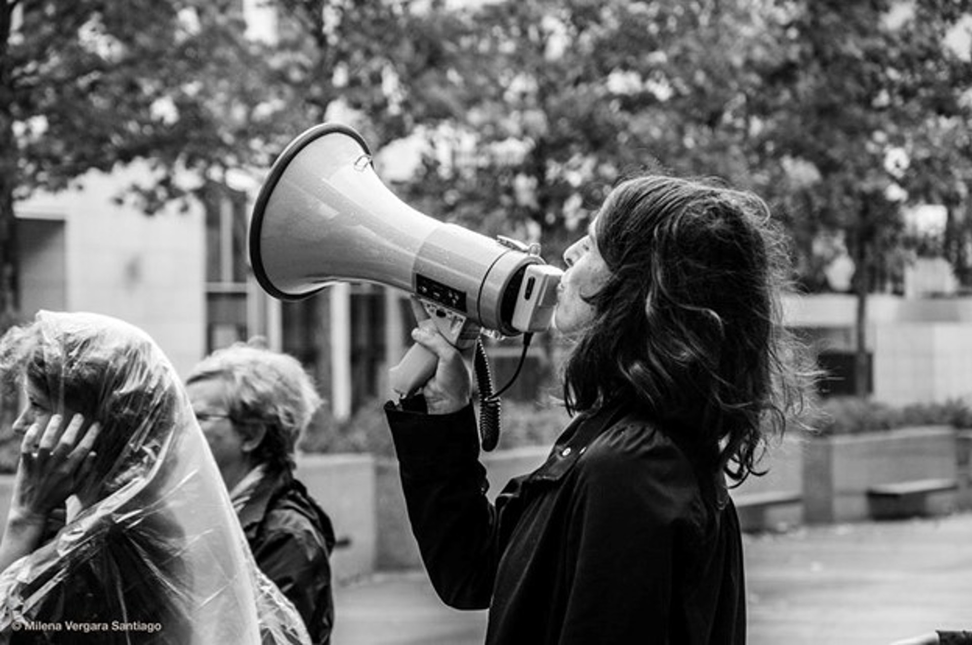 Black and white image of a person using a megaphone 