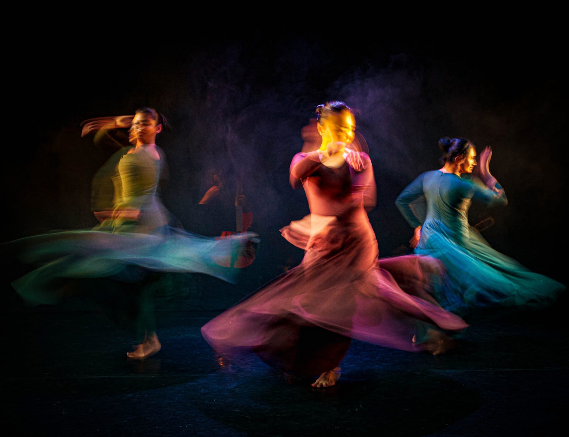 Three female south asian dancers spinning in dresses with motion blur Three female south asian dancers spinning in dresses with motion blur