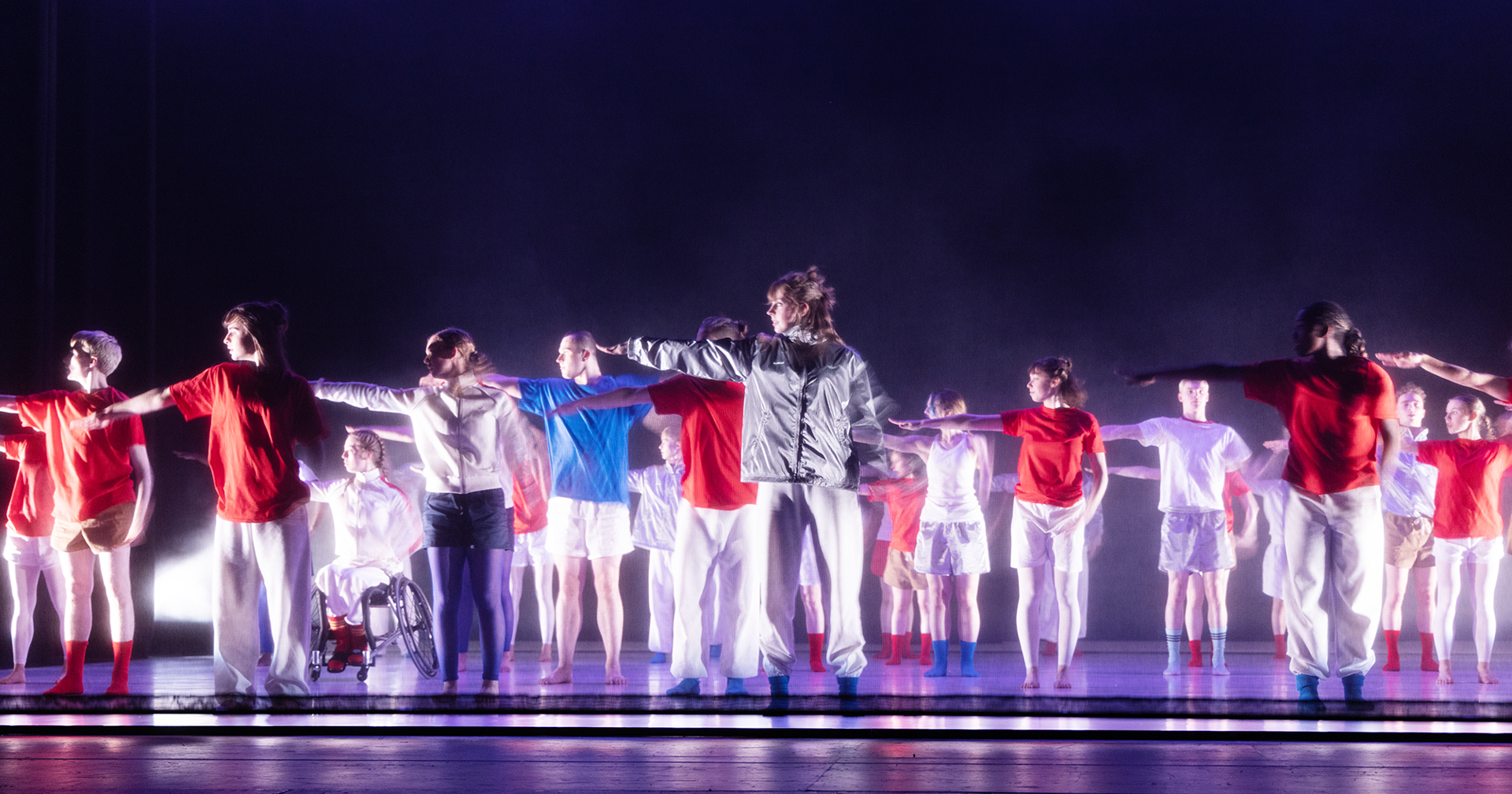 youth group on purple stage all wearing bright white, red and blue colourful casual clothes all pointing to the left. youth group on purple stage all wearing bright white, red and blue colourful casual clothes all pointing to the left.