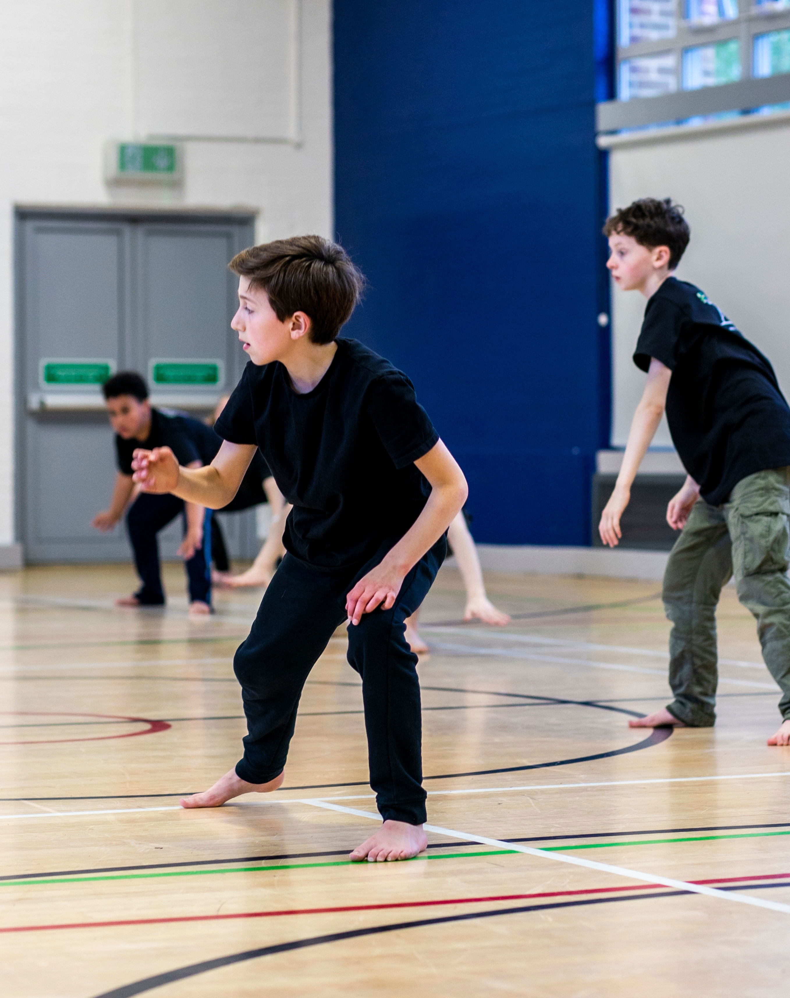 Three young boys dancing in a sports hall