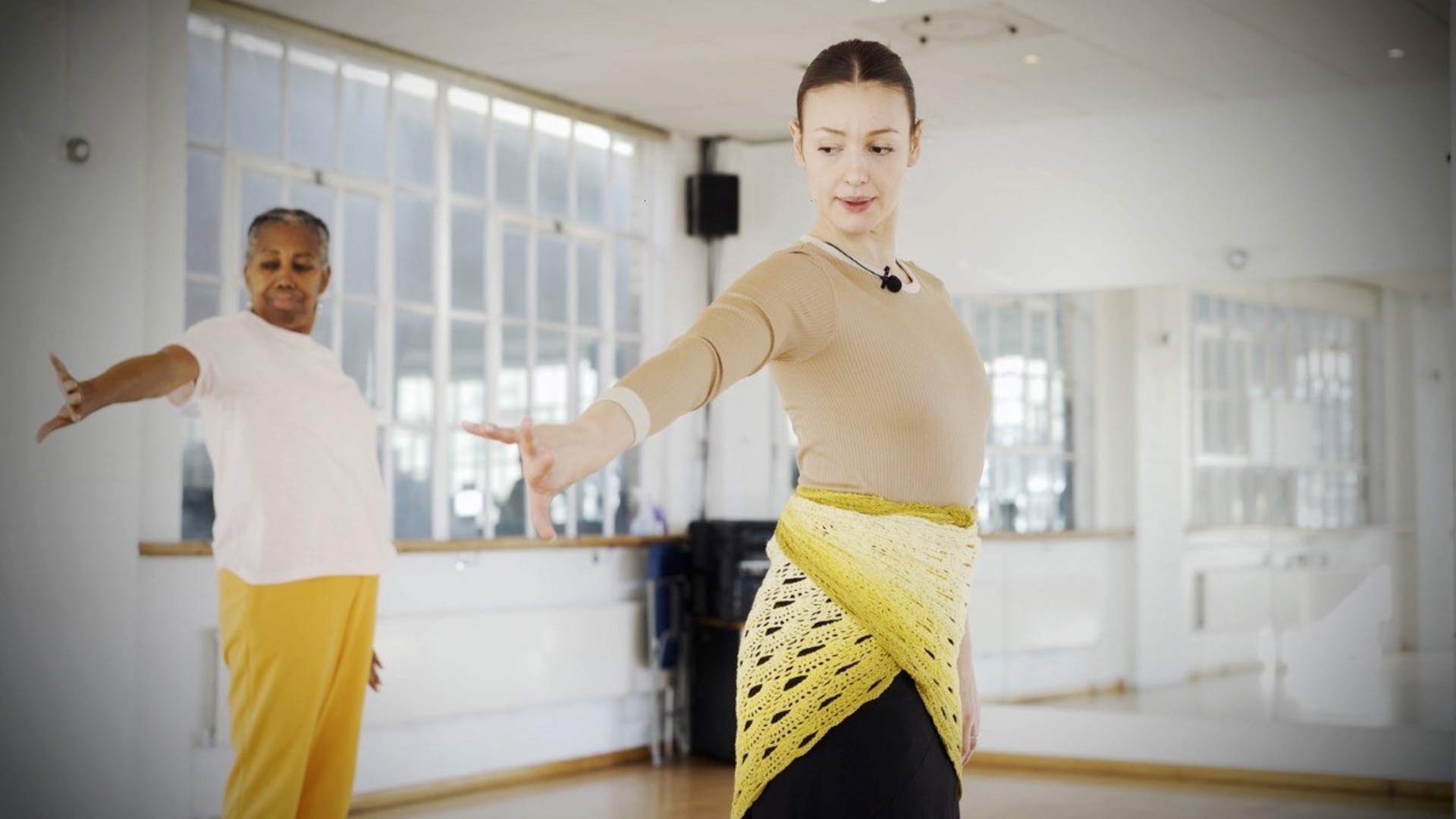 two female dancers long left hand out looking down in a mirrored dance studio two female dancers long left hand out looking down in a mirrored dance studio