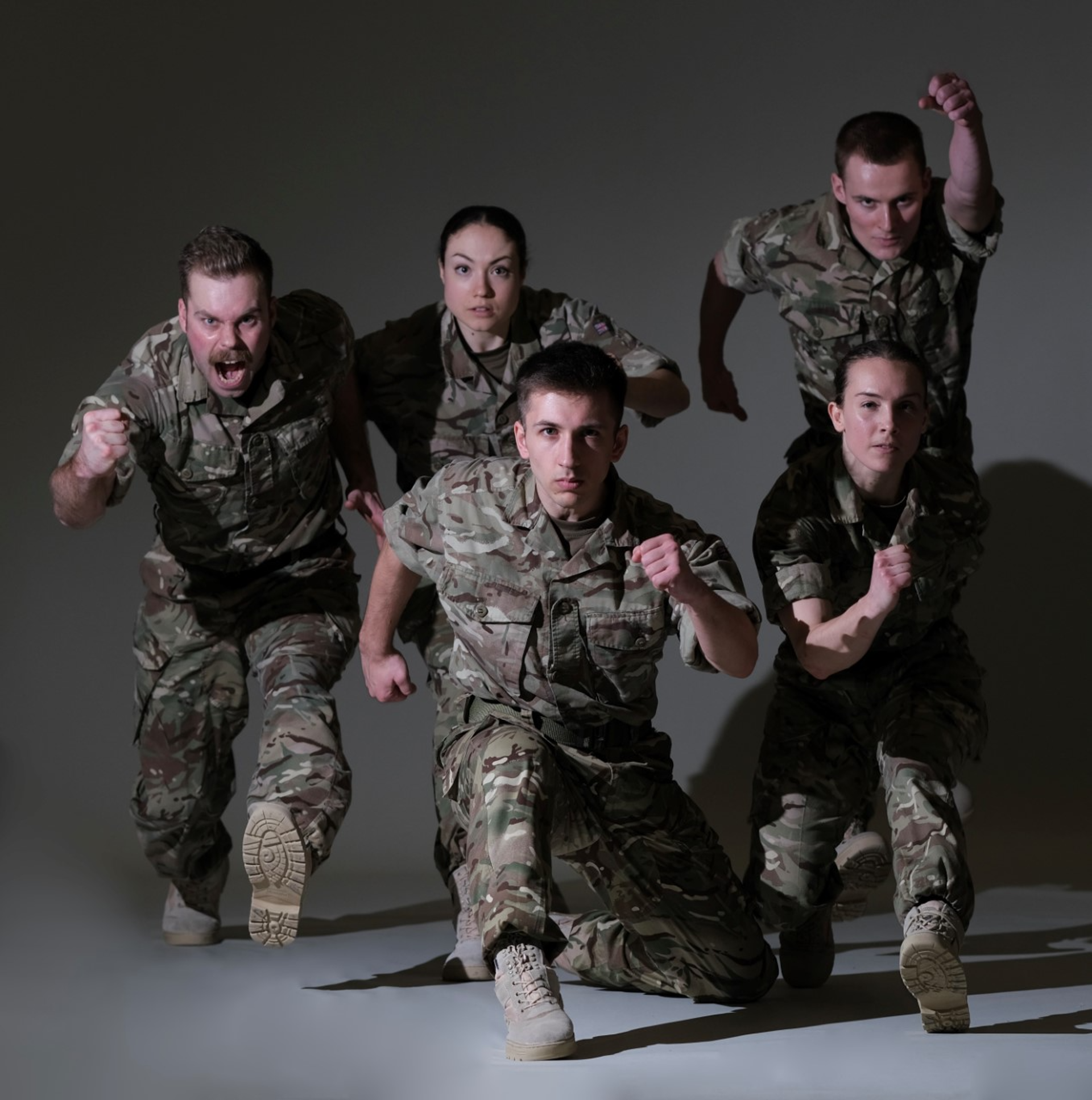 five dancers dressed as soldiers running towards he camera on a grey background five dancers dressed as soldiers running towards he camera on a grey background