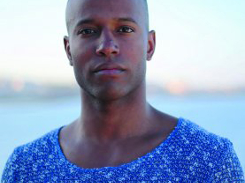 Headshot of Antoine Marc. Global majority male with a bald head wearing blue t-shirt
